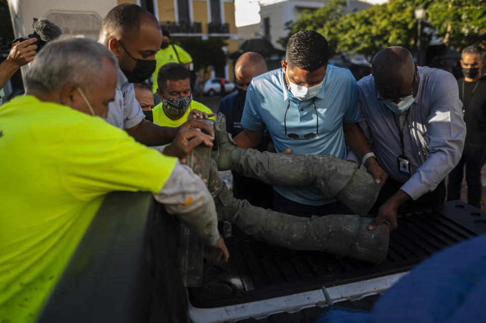 A statue of Spanish explorer Juan Ponce de León lays in a truck as municipal workers recover its pieces in Plaza San Jose in San Juan, Puerto Rico, Monday, Jan. 24, 2022. Unknown people toppled the in the pre-dawn hours of Monday ahead of a visit of King Felipe VI to the U.S. Caribbean territory of Puerto Rico. (AP Photo/Carlos Giusti)