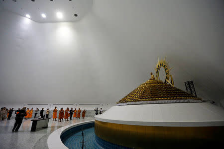 Department of Special Investigation (DSI) officers and Buddhist monks from the Wat Phra Dhammakaya temple are seen inside of the golden statue chamber during an inspection of the temple, in Pathum Thani province, Thailand March 10, 2017. REUTERS/Chaiwat Subprasom