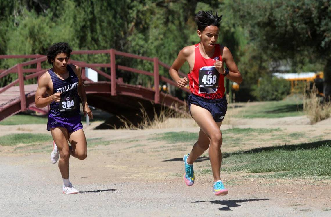 Sanger High senior Myles Nicasio runs ahead of Madera South senior Vidal Luna during the Dennis DeWitt Invitational at Lions Town & Country Park in Madera on Aug. 27, 2022. Vidal placed fifth in 9:21.9 and Nicasio was sixth in 9:24.5 on the 3,000-meter course.