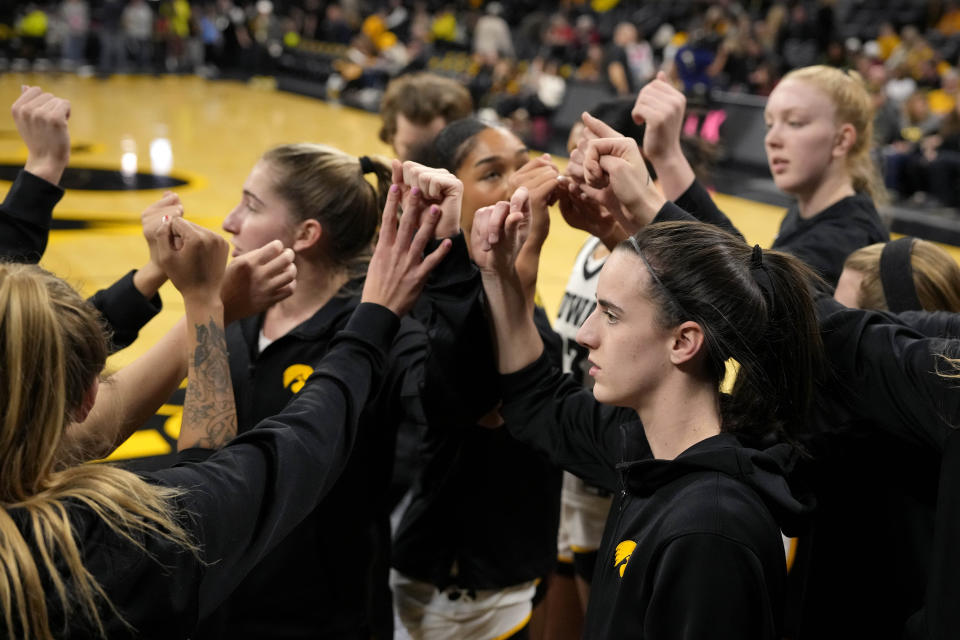 Iowa players, including guard Caitlin Clark, right foreground, huddle before the team's NCAA college basketball game against Michigan, Thursday, Feb. 15, 2024, in Iowa City, Iowa. (AP Photo/Matthew Putney)