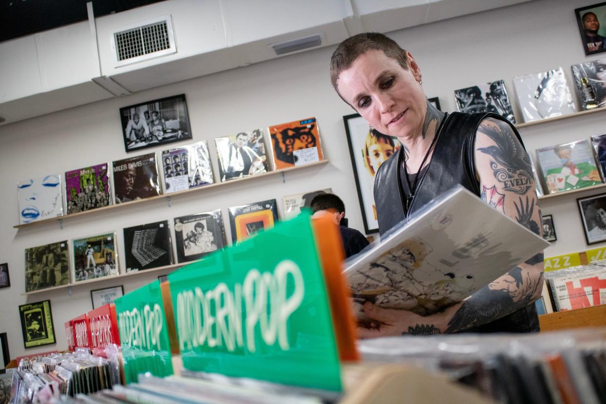 Laura Jane Grace looks through different music genres while at Sunshine Records in Gainesville, Fla., on April 14, 2023.