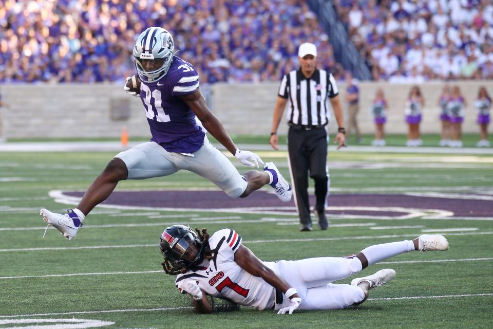 Kansas State Wildcats running back DJ Giddens (31) jumps over Southeast Missouri State Redhawks defensive back Lawrence Johnson (7) during the first quarter at Bill Snyder Family Football Stadium.