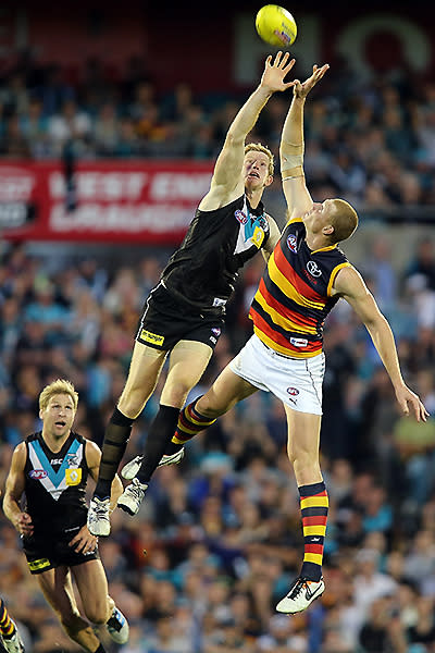 Matthew Lobbe of the Power and Sam Jacobs of the Crows compete for the ball.