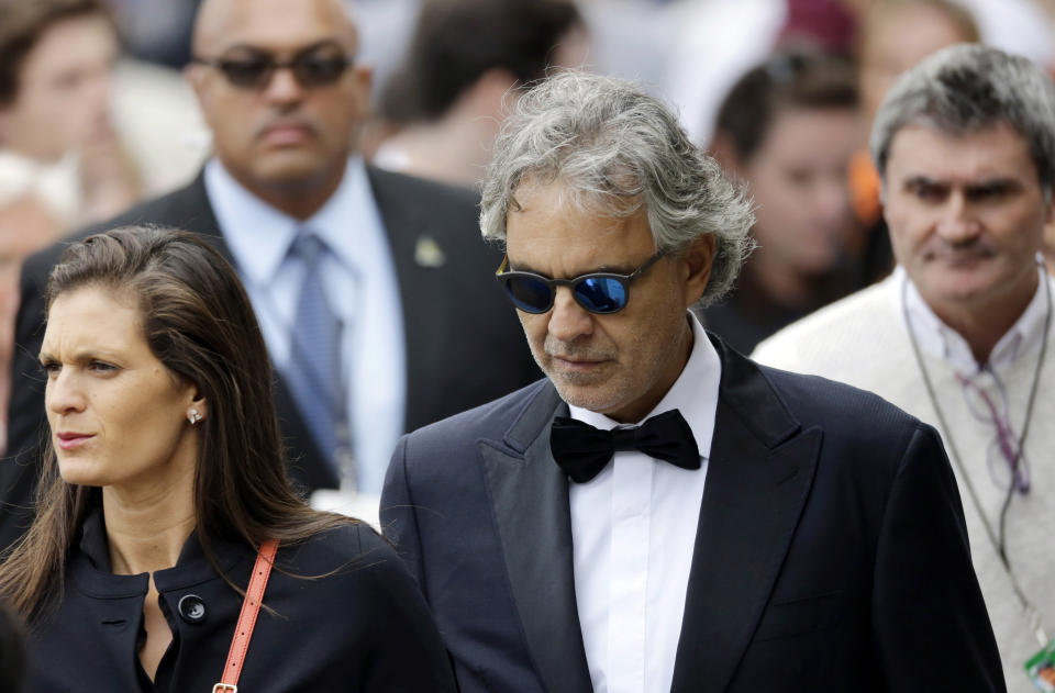 Italian tenor Andrea Bocelli (C) walks to receive communion.