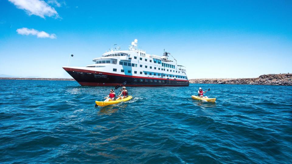 2 kayaks in front of hurtigruten expeditions cruise ship