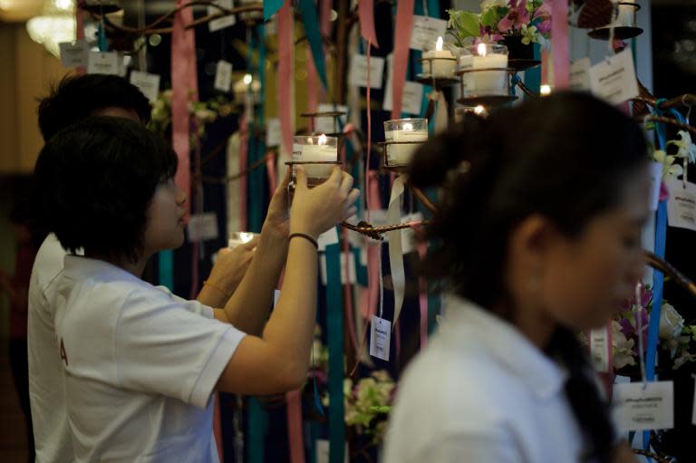Volunteers place candles during a mass prayer service for passengers onboard missing Malaysia Airlines (MAS) flight MH370 in Kuala Lumpur on April 6, 2014