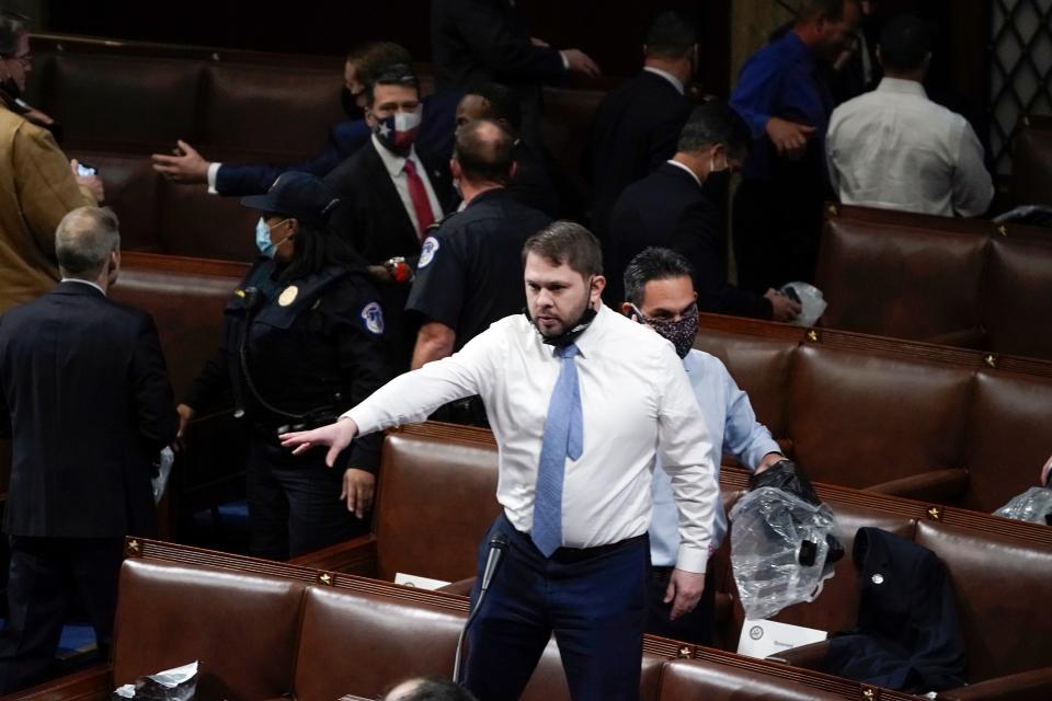Rep. Ruben Gallego, D-Ariz., stands on a chair as lawmakers prepare to evacuate the floor as mob members try to break into the House Chamber at the U.S. Capitol on Wednesday, Jan. 6, 2021, in Washington.