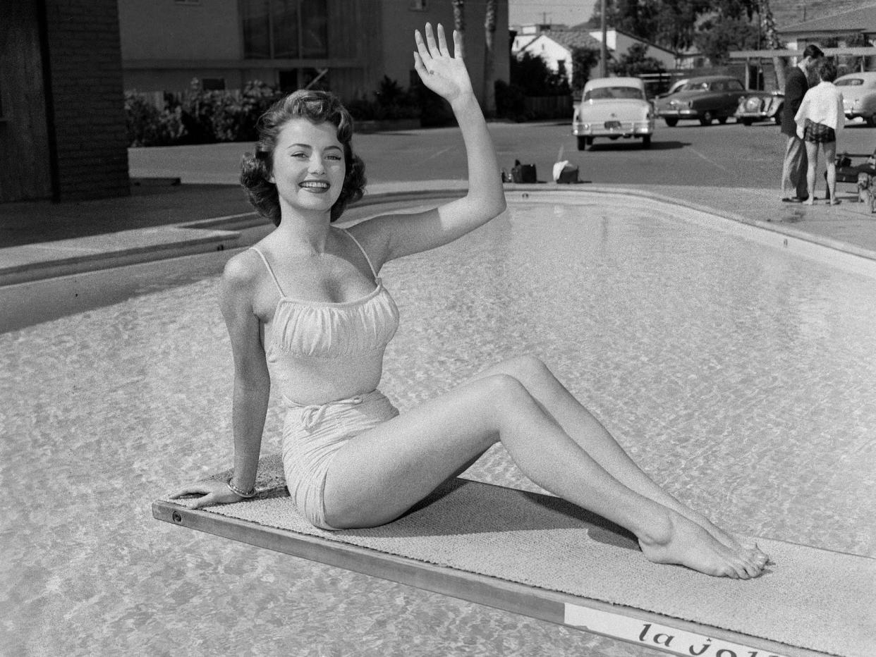 Miss USA Jackie Loughery waves as she poses on a diving board.