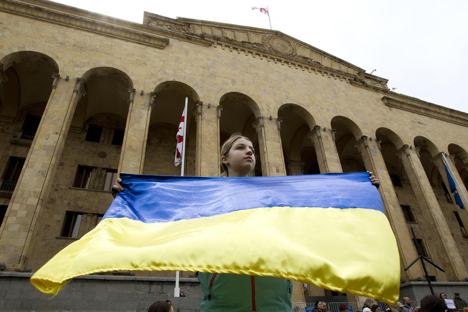 A demonstrator holds a Ukrainian national flag during a protest against the Russian invasion of Ukraine in Tbilisi, Georgia, Sunday, May 8, 2022, a day before Russia celebrates Victory Day, marking 77 years of the victory in WWII. (AP Photo/Shakh Aivazov)