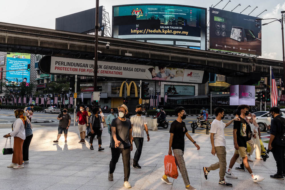 People are seen wearing protective masks as they walk along the Bukit Bintang shopping area in Kuala Lumpur on October 9, 2021. — Picture by Firdaus Latif