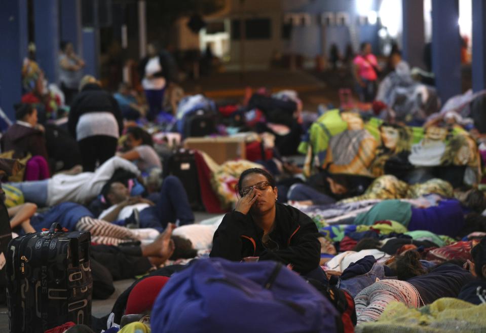 A Venezuelan migrants migrants rest near the border checkpoint as they wait to pass migration controls before the deadline on new regulations, in Tumbes, Peru, Friday, June 14, 2019. Venezuelan citizens are rushing to enter Peru before the implementation of new entry requirements on migrants fleeing the crisis-wracked South American nation. (AP Photo/Martin Mejia)