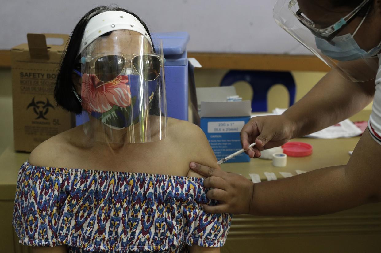 Filipino nurse Monette Villaraza gets China's Sinovac vaccine for COVID-19 under a government program at a school in Quezon City, Philippines on Tuesday, March 30, 2021. Philippine officials placed Metropolitan Manila and four outlying provinces, a region of more than 25 million people, back to a lockdown Monday at the height of the Lenten and Easter holiday travel season as they scrambled to control an alarming surge in coronavirus infections.