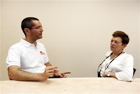 Nadav Kidron, CEO of Oramed Pharmaceuticals, holds an insulin pill as he poses for a photo with his mother, Oramed's chief scientific officer, Miriam Kidron (R) at the company's offices in Jerusalem September 29, 2013. REUTERS/Baz Ratner