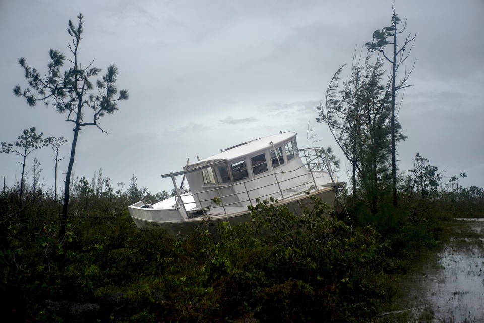 A boat thrown onshore by the Hurricane Dorian lays stranded next to a highway near Freeport, Grand Bahama, Bahamas, Tuesday Sept. 3, 2019. (Photo: Ramon Espinosa/AP)