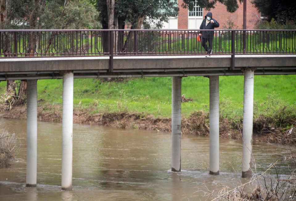 The storm-fed Calaveras River rises near the Donald B. Wood pedestrian bridge in Stockton on Tuesday, March 14, 2023.