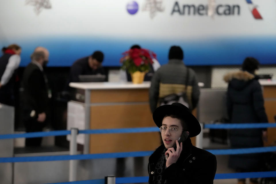 A traveler talks on the phone at O'Hare International Airport in Chicago, Thursday, Dec. 22, 2022. (AP Photo/Nam Y. Huh)