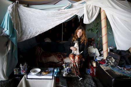 Karen Souza, 55, poses for a portrait with her dog Handsome by the tent in which she lives, under a freeway on a street in Los Angeles, California, United States, November 13, 2015. REUTERS/Lucy Nicholson