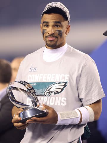 <p>Tim Nwachukwu/Getty</p> Jalen Hurts of the Philadelphia Eagles holds the George Halas Trophy after defeating the San Francisco 49ers to win the NFC Championship Game in January 2023 in Philadelphia, Pennsylvania.