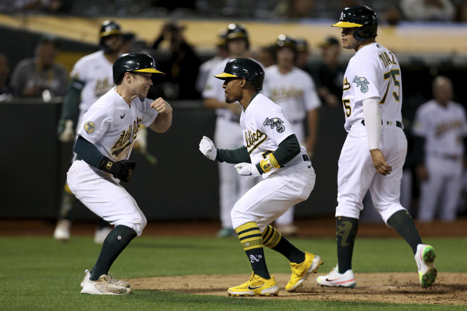 Oakland Athletics' Tony Kemp, center, celebrates with Nick Allen, left, and Jordan Diaz, right, after hitting a three-run home run against the Seattle Mariners during the fifth inning of a baseball game in Oakland, Calif., Tuesday, Sept. 20, 2022. (AP Photo/Jed Jacobsohn)