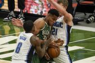 Milwaukee Bucks' Giannis Antetokounmpo battles for a loose ball with Orlando Magic's Dwayne Bacon and Moritz Wagner during the second half of an NBA basketball game Tuesday, May 11, 2021, in Milwaukee. (AP Photo/Morry Gash)