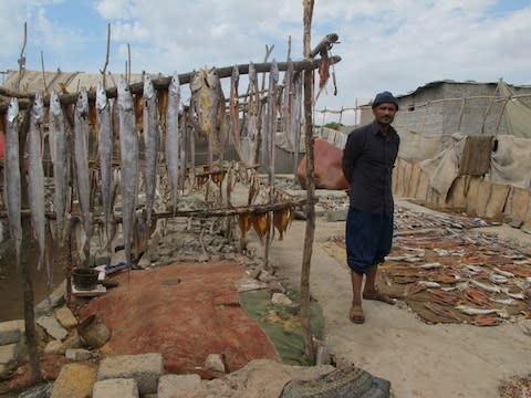 A fisherman sells his catches at Machar Colony, Karachi - Credit: Ben Farmer