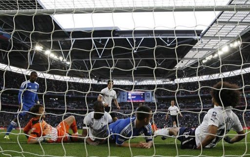 Tottenham Hotspur's Cameroon player Benoit Assou-Ekotto (R) attempts to stop the shot from Chelsea's Spanish player Juan Mata but referee Martin Atkinson awards the goal during the match against Tottenham Hotspur and Chelsea at Wembley Stadium in London. Tottenham manager Harry Redknapp called for the swift introduction of goal-line technology after the key decision went against Spurs