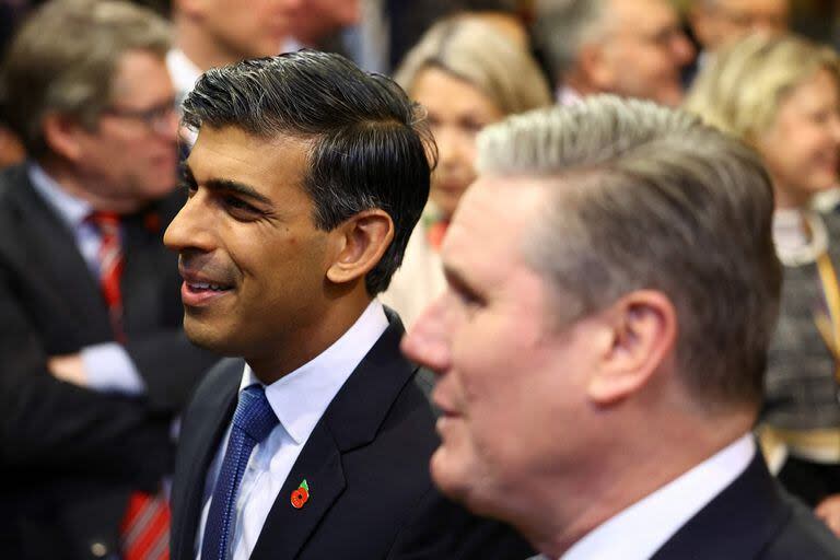 El primer ministro británico, Rishi Sunak, y el principal líder del Partido Laborista opositor de Gran Bretaña, Keir Starmer, caminan por el vestíbulo de los miembros de la Cámara de los Comunes durante la apertura estatal del Parlamento en las Casas del Parlamento en Londres el 7 de noviembre de 2023.