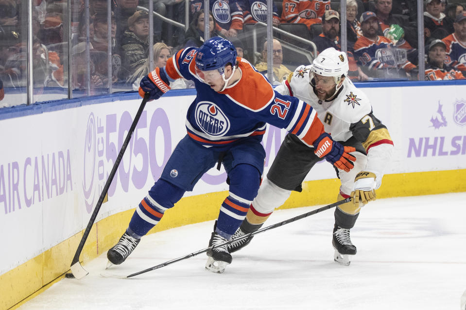 Vegas Golden Knights' Alex Pietrangelo (7) and Edmonton Oilers' Adam Erne (21) battle for the puck during the second period of an NHL hockey game in Edmonton, Alberta on Tuesday Nov. 28, 2023. (Jason Franson/The Canadian Press via AP)