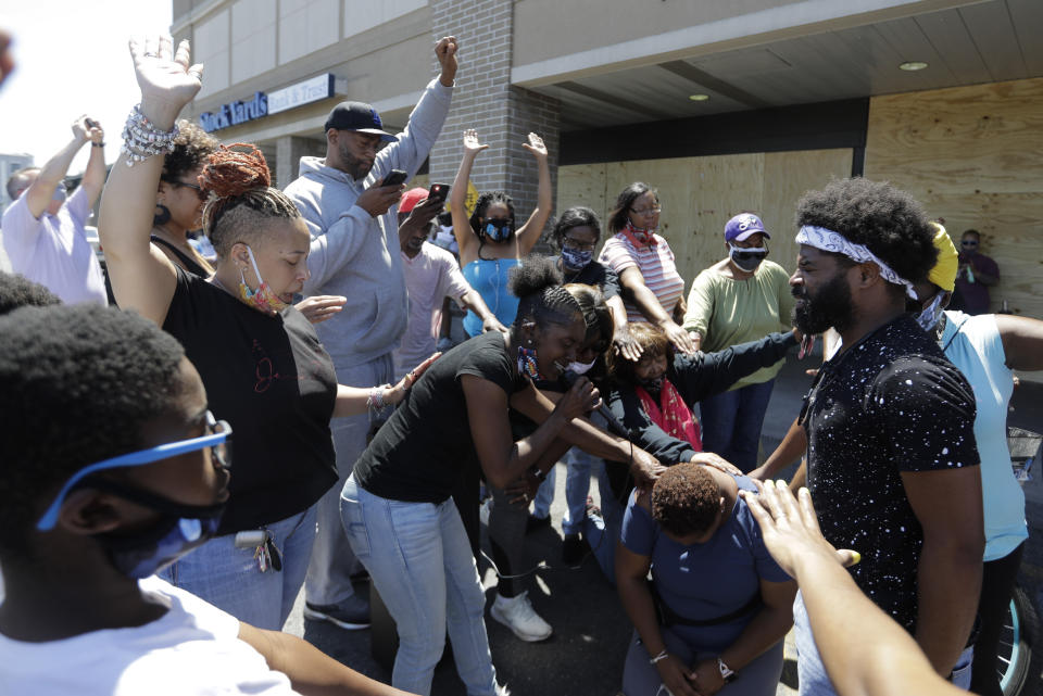 A group prays, Tuesday, June 2, 2020, in Louisville, Ky. near the intersection where David McAtee was killed Sunday evening. McAtee, the owner of a barbecue spot who was known for offering meals to police officers, died while police and National Guard soldiers were enforcing a curfew early Monday amid waves of protests over a previous police shooting. (AP Photo/Darron Cummings)