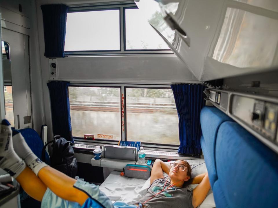 The author is seen laying down in a train sleeper car