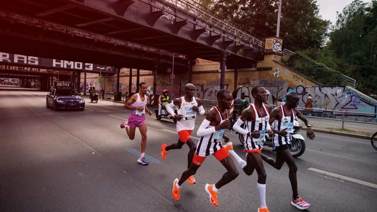 kipchoge in 2022 on his way to a world record in the streets of berlin with a team of three pacers