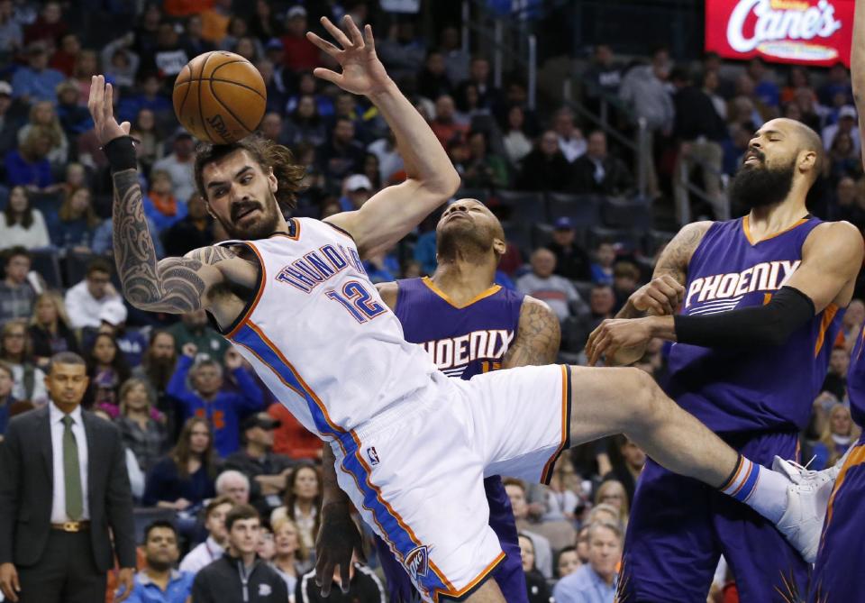 Oklahoma City Thunder center Steven Adams (12) loses the ball and falls to the floor following a foul in the second quarter of an NBA basketball game against the Phoenix Suns in Oklahoma City, Saturday, Dec. 17, 2016. Suns forward P.J. Tucker, center, and center Tyson Chandler, right, react. (AP Photo/Sue Ogrocki)