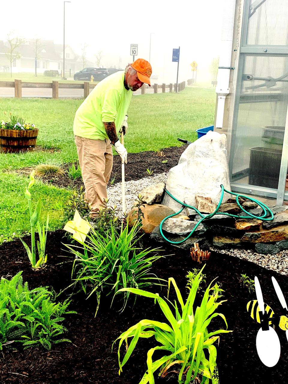  John Twomey, URI Master Gardener and leader of the greenhouse project at the RI Veterans Home. mulches a bed at the campus last spring.