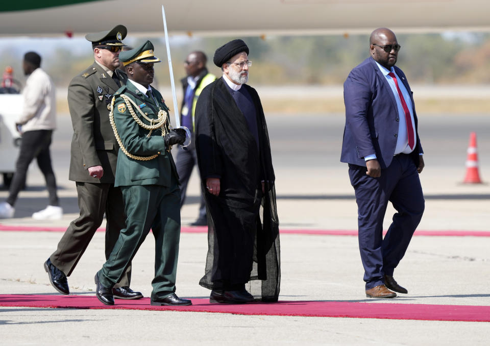 Iran's President Ebrahim Raisi, center, inspects the guard of honour upon his arrival at Robert Mugabe airport in Harare, Zimbabwe, Thursday, July 13, 2023. Iran's president is on a rare visit to Africa as the country, which is under heavy U.S. economic sanctions, seeks to deepen partnerships around the world. (AP Photo/Tsvangirayi Mukwazhi)