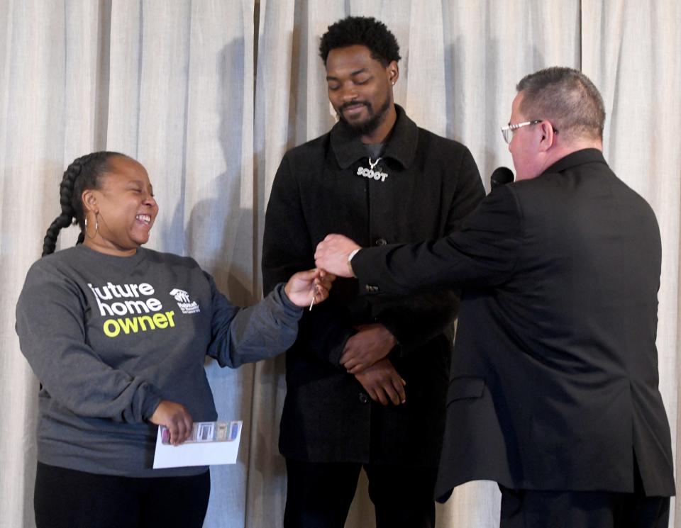 Catholic Diocese of Youngstown Bishop David Bonnar hands Ashya Mathis and Ronnie Dykes keys to their new home, which was built through Habitat for Humanity East Central Ohio with help from volunteers from Stark County Catholic churches.