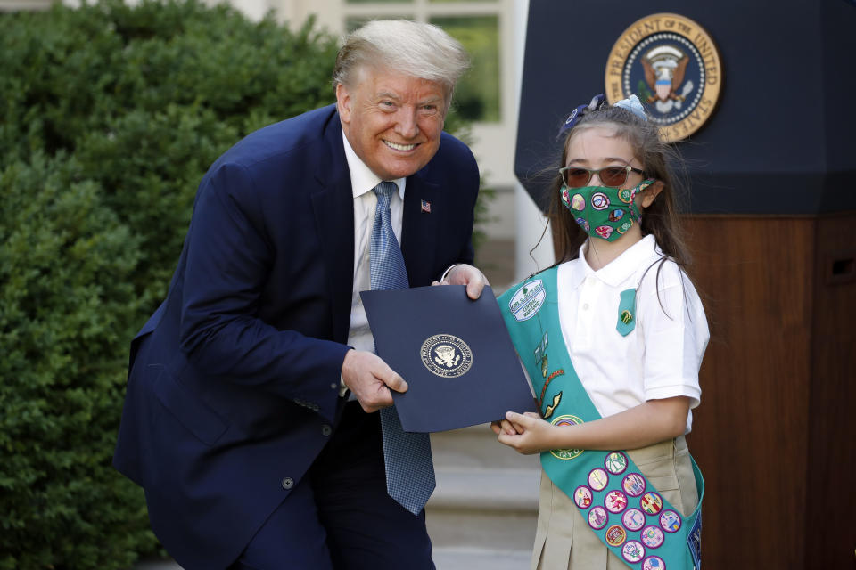 President Donald Trump poses for a photo with Girl Scout Troop 744 member Lauren Matney during a presidential recognition ceremony in the Rose Garden of the White House, Friday, May 15, 2020, in Washington. (AP Photo/Alex Brandon)