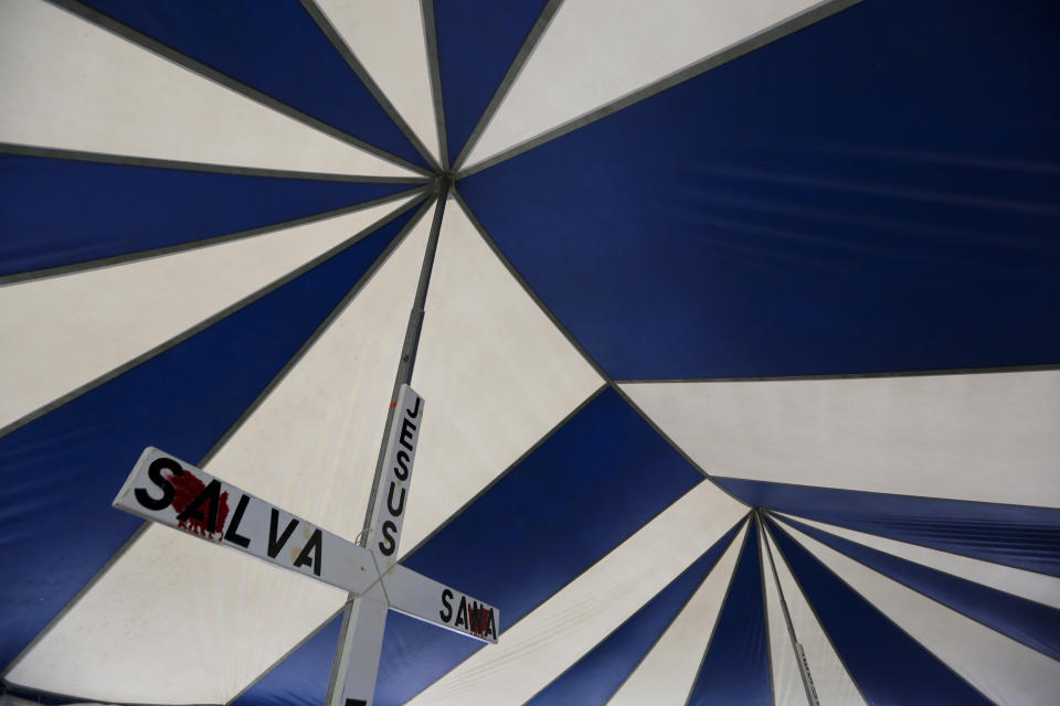 In this Oct. 11, 2019 photo, a cross stands inside a tent were volunteers give migrants free haircuts at a camp set up by migrants waiting near a legal port of entry bridge in Matamoros, Mexico. In years past, migrants seeking asylum in the United States moved quickly through this violent territory on their way to the U.S., but now due to Trump administration policies, they remain here for weeks and sometimes months as they await their U.S. court dates, often in the hands of gangsters who hold Tamaulipas state in a vice-like grip. (AP Photo/Fernando Llano)