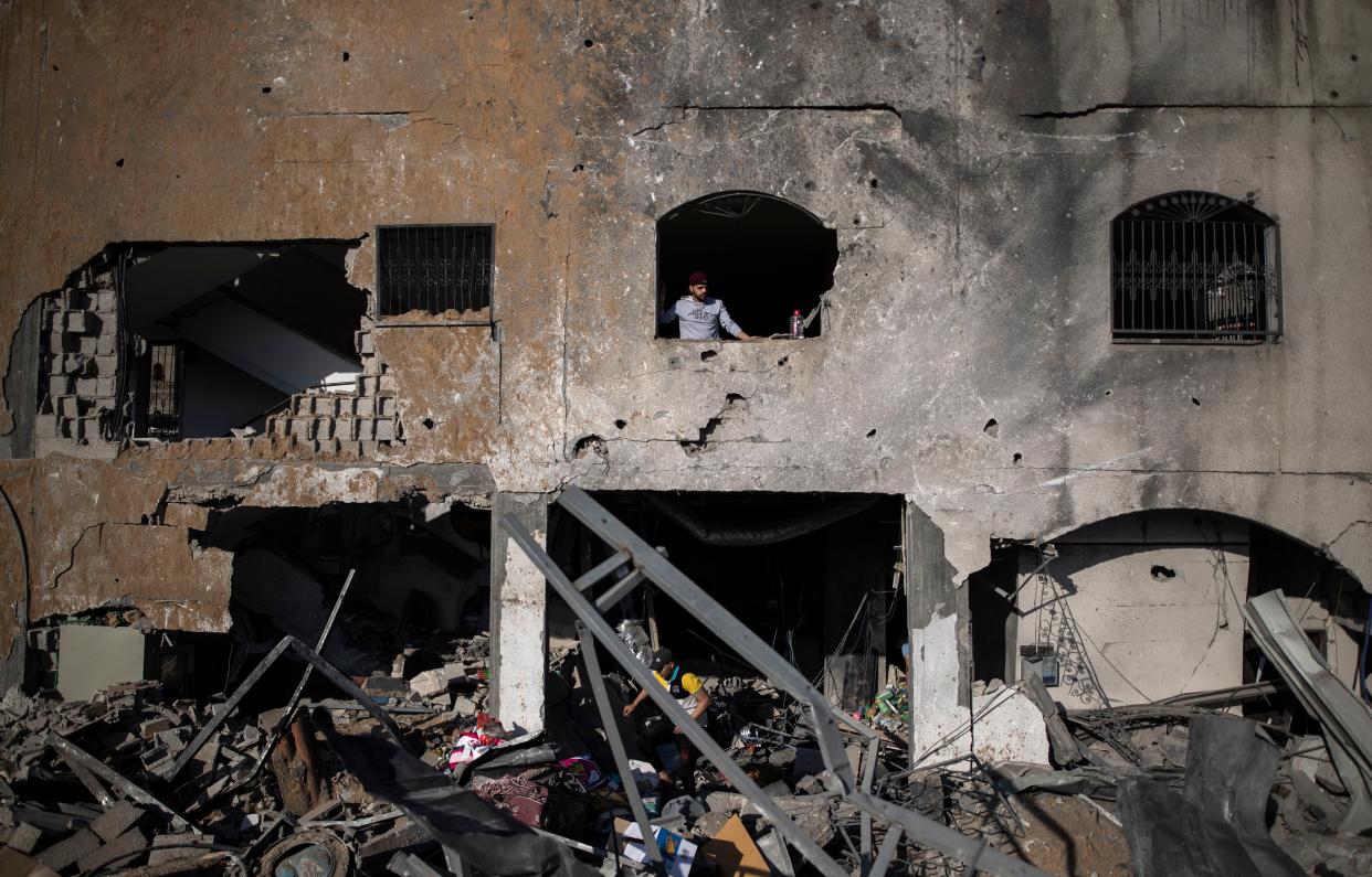 Palestinians inspect their destroyed home after being hit by Israeli airstrikes in the town of Beit Lahiya, northern Gaza Strip on Thursday, May 13, 2021.