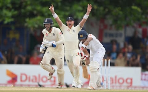  England wicketkeeper Ben Foakes and slip Ben Stokes celebrate as Sri Lanka batsman Dinesh Chandimal is bowled by Jack Leach  - Credit: Stu Forster/Getty Images