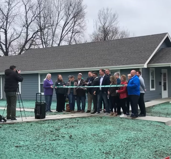 Members of Cornerstone of Topeka, the city’s governing body, and Shirley Construction cut a ribbon at two new affordable duplexes.