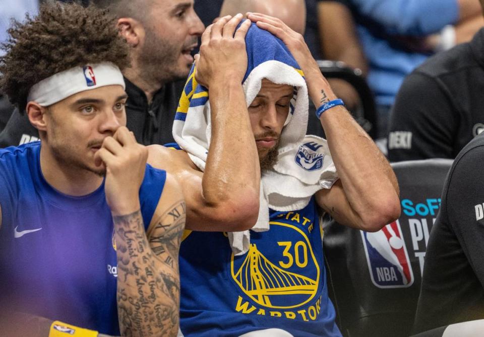 A dejected Golden State Warriors guard Stephen Curry (30) sits on a bench as his team falls behind the Sacramento Kings during an NBA play-in game at Golden 1 Center on Tuesday.