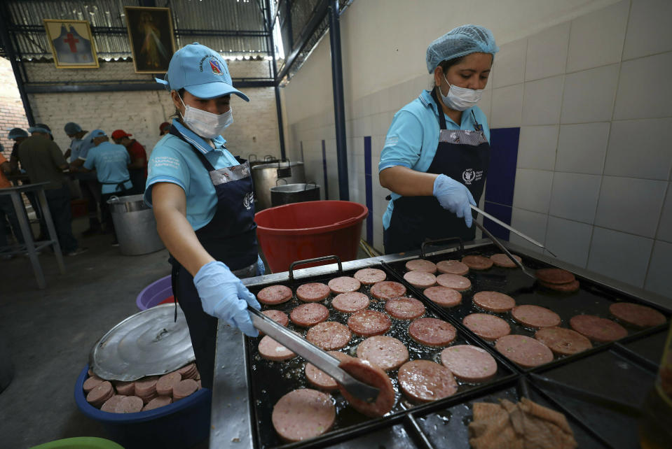 Voluntarios fríen mortadela en el refugio de migrantes "Divina Providencia" en La Parada, cerca de Cúcuta, Colombia, en la frontera con Venezuela, el lunes 18 de febrero de 2019. (AP Foto / Fernando Vergara)