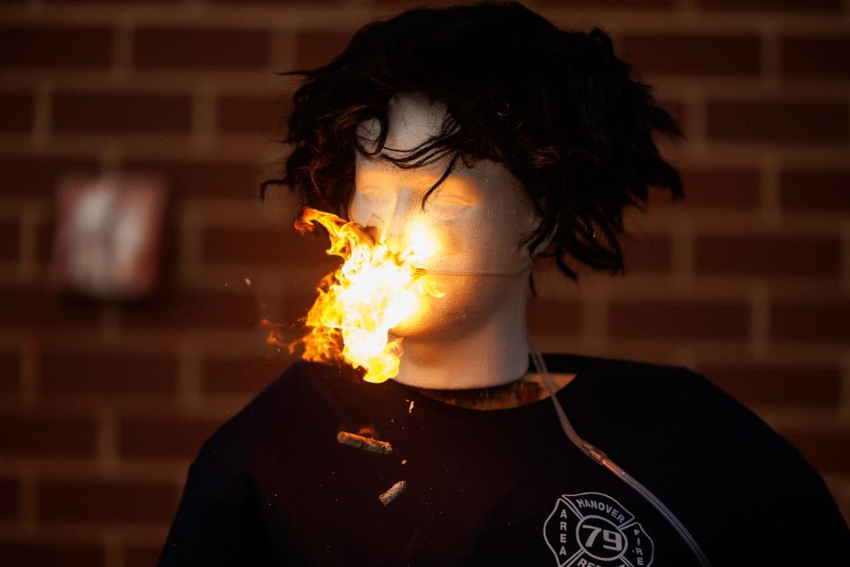A cigarette is thrown to the ground as a burst of flames shoots across the face of a mannequin wearing an oxygen cannula while Hanover Area Fire & Rescue firefighters perform a demonstration of smoking while using home oxygen, Tuesday, Jan. 23, 2024, at the Clover Lane firehouse in Penn Township.