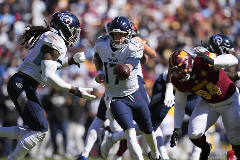 Tennessee Titans quarterback Ryan Tannehill, center, hands the ball off to running back Derrick Henry in the first half of an NFL football game against the Washington Commanders, Sunday, Oct. 9, 2022, in Landover, Md. (AP Photo/Jess Rapfogel)