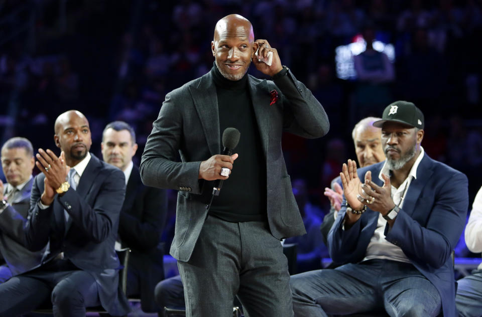 Former Detroit Piston Chauncey Billups, center, addresses fans at Little Caesars Arena while Richard Hamilton, left, and Ben Wallace look on during a celebration of their 2004 NBA Championship during halftime of an NBA basketball game against the Charlotte Hornets, Sunday, April 7, 2019, in Detroit. (AP Photo/Duane Burleson)