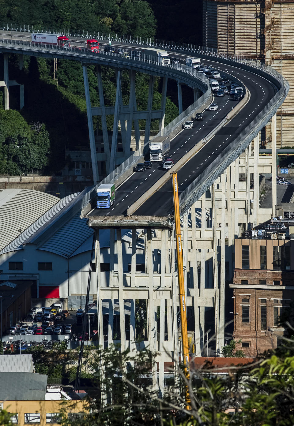 FILE - A general view of the collapsed Morandi highway bridge in Genoa, northern Italy, Wednesday, Aug. 15, 2018. Fifty-nine people went on trial Thursday, July 7, 2022, for the 2018 collapse of Genoa’s Morandi bridge, accused of manslaughter and other charges in the deaths of 43 people.The defendants include former executives and experts of the company that manages many of Italy’s bridges and highways, as well as former officials of the transport and infrastructure ministry. (AP Photo/Nicola Marfisi)