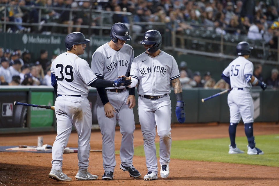 New York Yankees' Jose Trevino (39), left to right, congratulates Anthony Rizzo and Gleyber Torres, after they scored against the Oakland Athletics on a double hit by Josh Donaldson during the seventh inning of a baseball game in Oakland, Calif., Thursday, Aug. 25, 2022. (AP Photo/Godofredo A. Vásquez)