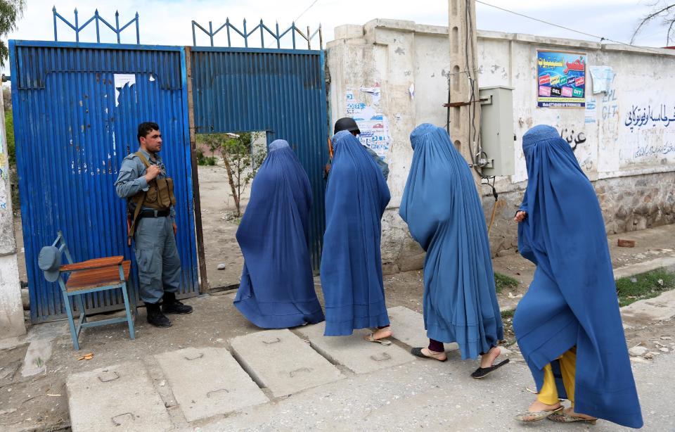 Afghan women enter a polling station to vote in Jalalabad, east of Kabul, Afghanistan, Saturday, April 5, 2014. Across Afghanistan, voters turned out in droves Saturday to cast ballots in a crucial presidential election in what promises to be the nation's first democratic transfer of power. The vote will decide who will replace President Hamid Karzai, who is barred constitutionally from seeking a third term. (AP Photo/Rahmat Gul)
