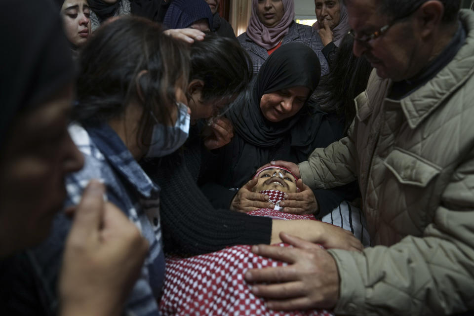 Palestinian mourners gather around the body of Omar Manaa during his funeral in the West Bank refugee camp of Deheishe near the city of Bethlehem, Monday, Dec. 5, 2022. Palestinian health officials say Manaa, a 22-year-old Palestinian man, was killed by Israeli fire during a military raid in the occupied West Bank. The army said it opened fire after a crowd attacked soldiers with stones and firebombs. (AP Photo/Mahmoud Illean)