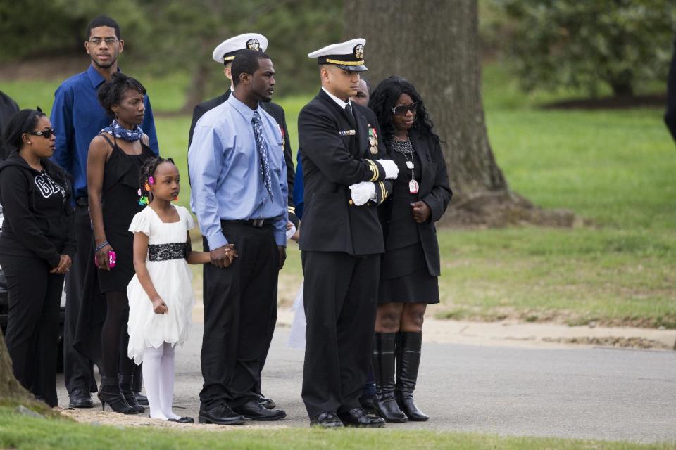 Sharon Blair, mother of U.S. Navy Petty Officer 2nd Class Mark Mayo, of Hagerstown, Md., right, waits for the arrival of her son's casket during a burial service at Arlington National Cemetery in Arlington, Va., Friday, April 25, 2014. Mayo was killed aboard the USS Mahan at Naval Station Norfolk, Va., after he dove in front of another sailor to protect her from a civilian truck driver who had seized her gun. Mayo was awarded the Navy Marine Corps Medal, the highest non-combatant decoration for heroism by a sailor or Marine. (AP Photo/ Evan Vucci)